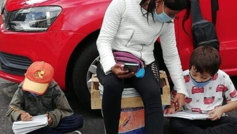 Madre usa el internet de la calle para ayudar a sus hijos a estudiar mientras cuida automóviles